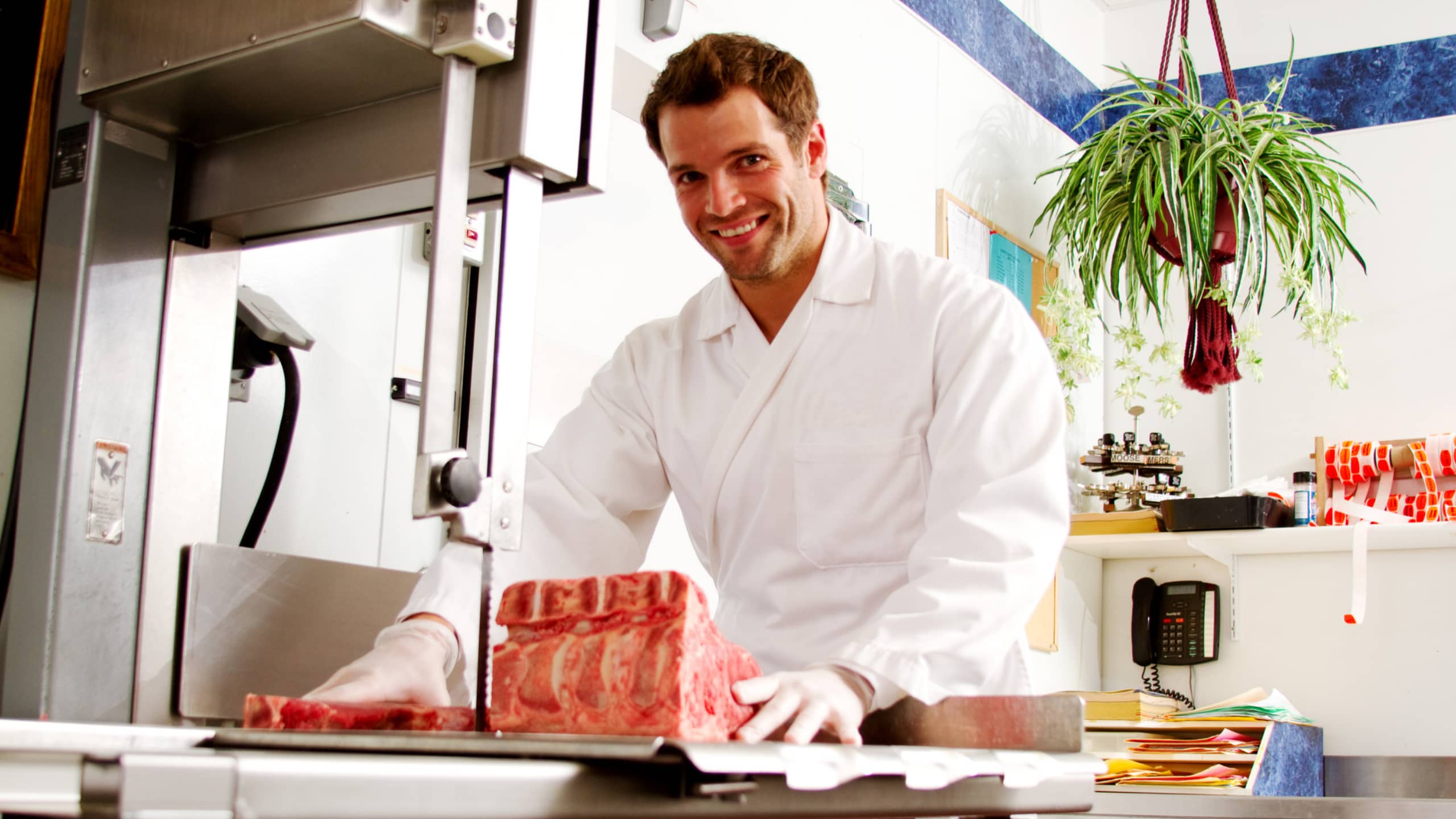 butcher cutting meat on band saw large